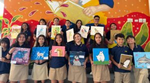 Niños mostrando pinturas de animales en un mural colorido en Huila TV, educación artística infantil, creatividad en estudiantes, arte y cultura en Colombia, programa educativo para niños.