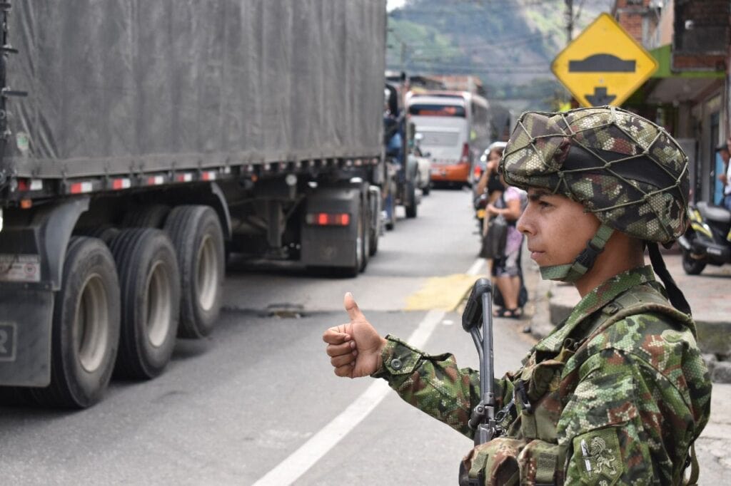 Soldado en tránsito en una vía congestionada en Huila, Colombia, durante operación militar. | Imagen del canal Huila TV mostrando seguridad y presencia militar en zonas urbanas de Huila.