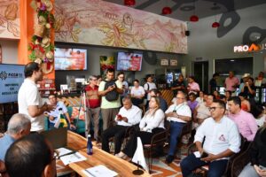 1. Personas en reunión de negocios en Huila TV, transmisión en vivo desde un restaurante turístico en Colombia con decoración tradicional y tecnología moderna.