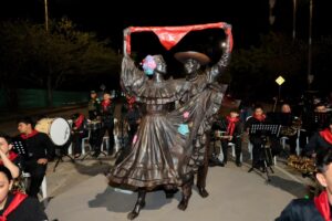 Bailarines de cumbia en Huila TV, resaltando tradiciones culturales y folclóricas del Huila con una estatua de bronce en movimiento.