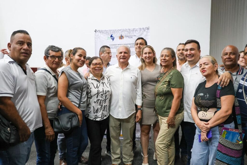 Alto contenido de un grupo diverso de personas en evento oficial en Huila TV, con logotipo y cartel de fondo, promoviendo la integración y el desarrollo regional en el departamento del Huila.