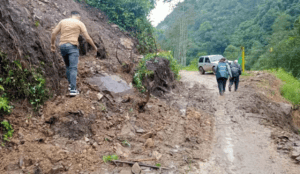 1. Personas inspeccionando un desprendimiento de tierra en una vía rural en Huila, Colombia.