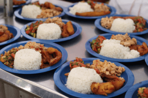 Platos con arroz y pollo en Neiva, Huila, Colombia, mostrando la gastronomía local en un evento escolar.