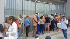 Personas haciendo fila frente a una oficina de salud en Huila, reportando más de 6,000 tutelas por problemas en el acceso a servicios médicos.
