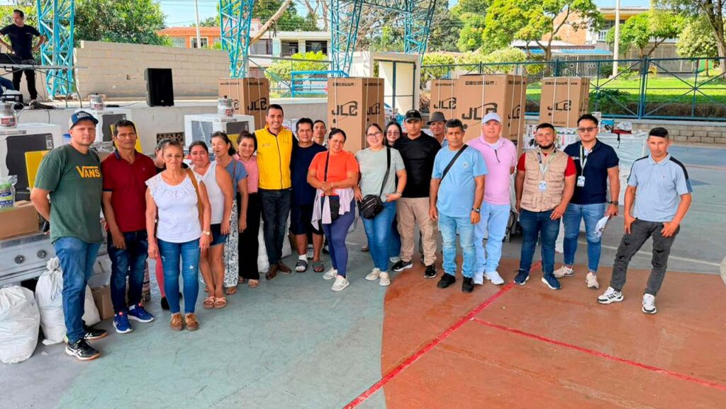 Personas participando en evento de apoyo a víctimas en Garzón, con cajas y equipos de trabajo.