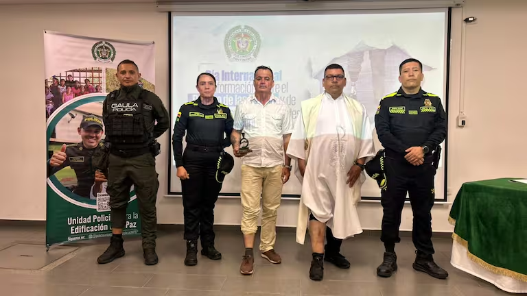 Imagen de oficiales y expertos en desminado en Huila, Colombia, durante una ceremonia de reconocimiento por avances en la eliminación de minas antipersonal en la región.