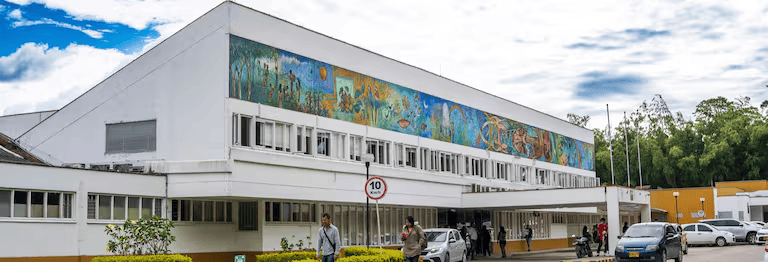 Huila TV en el Museo de Neiva, con arte mural colorido en la fachada y visitantes disfrutando del espacio cultural en un día soleado.