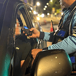 Policía de tránsito realizando control de documentos a conductor en la noche en Huila, Colombia.