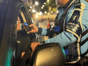 Policía de tránsito realizando control de documentos a conductor en la noche en Huila, Colombia.
