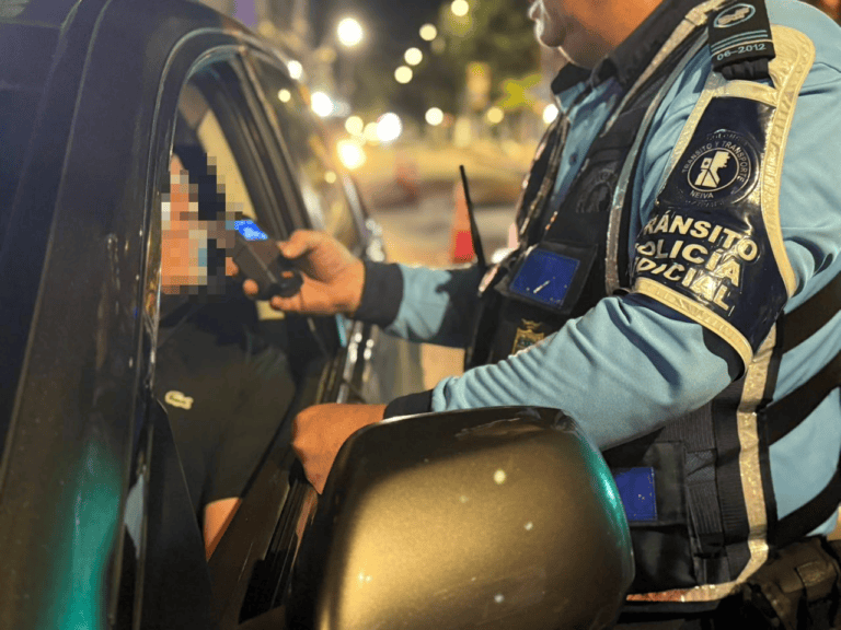 Policía de tránsito realizando control de documentos a conductor en la noche en Huila, Colombia.
