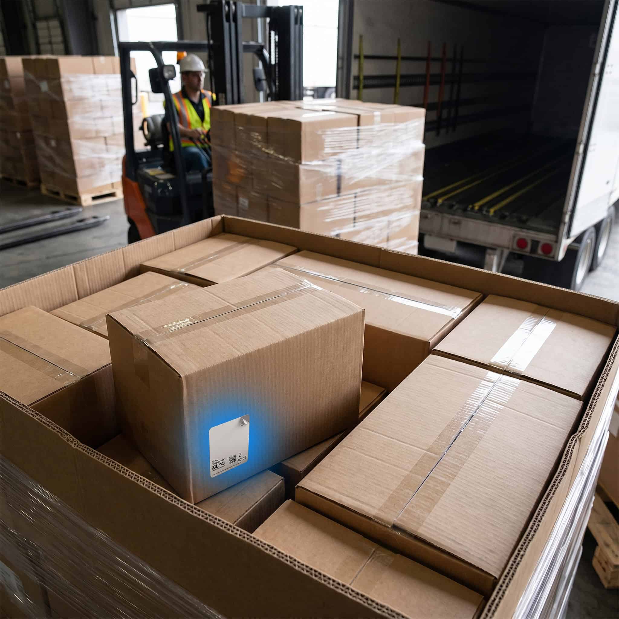 Warehouse worker using wireless cargo sensors for supply chain visibility.