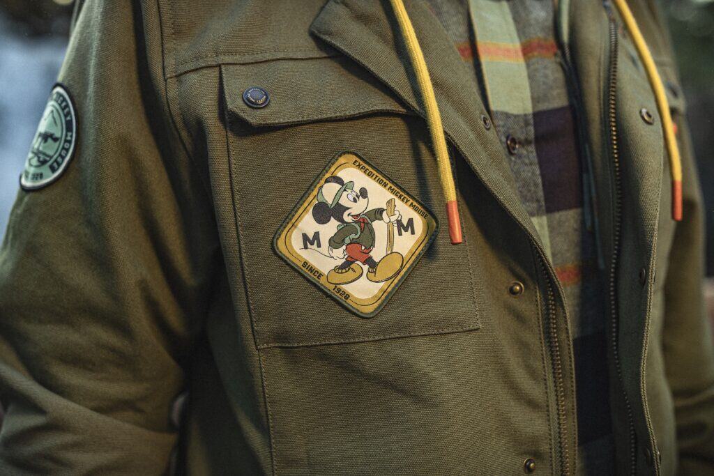 Mickey Mouse Disney adventure patch on green backpack, vintage style, outdoor travel accessory.