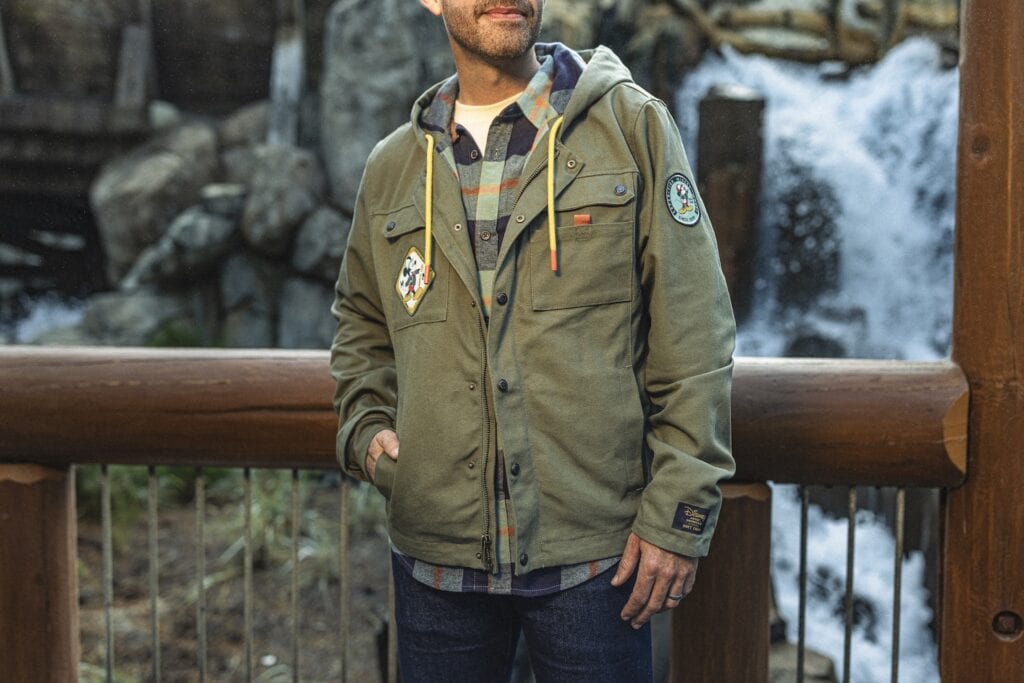Casual outdoor jacket with Disney patches and a plaid hoodie, perfect for Disney fashion enthusiasts.