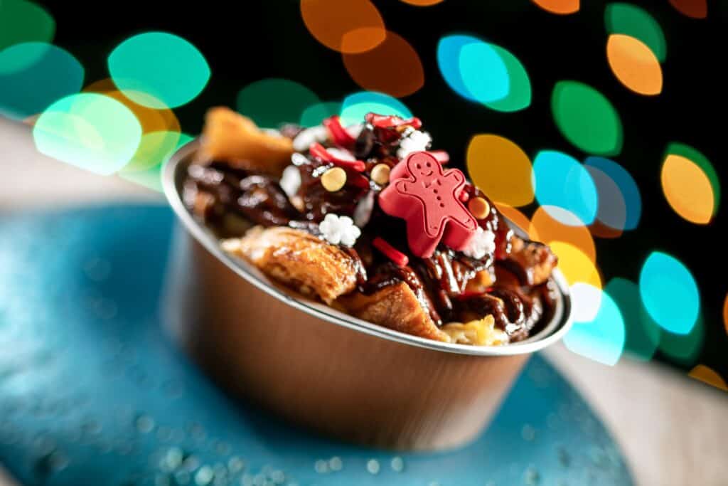 Sweet holiday dessert with gingerbread, chocolate, and festive decorations against colorful bokeh lights.