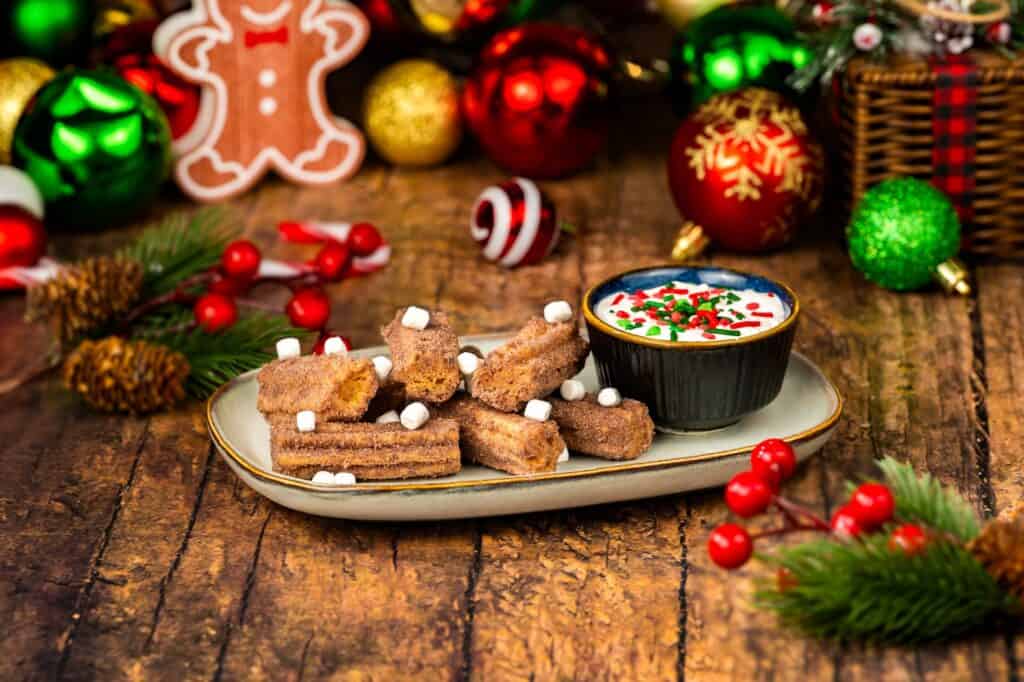 Festive Christmas treats with hot cocoa, gingerbread, and holiday decorations on rustic table.