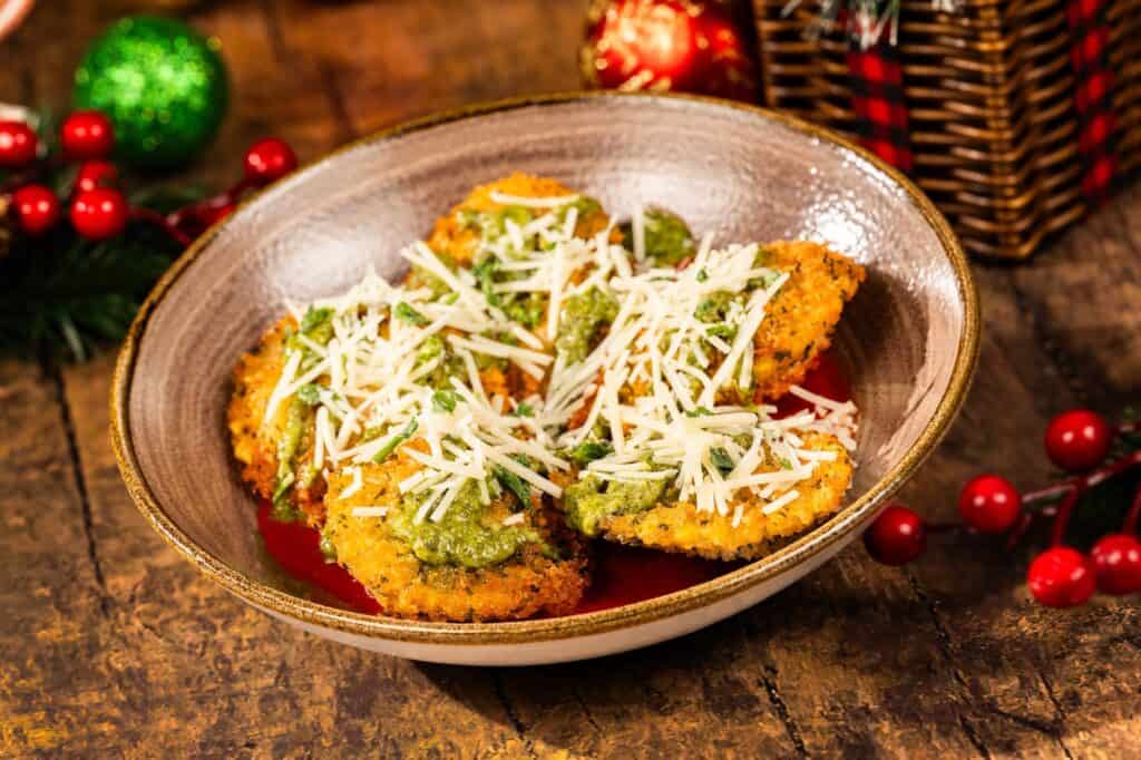Crunchy fried mozzarella sticks topped with shredded cheese and herbs, served on a rustic plate with holiday decorations in the background.