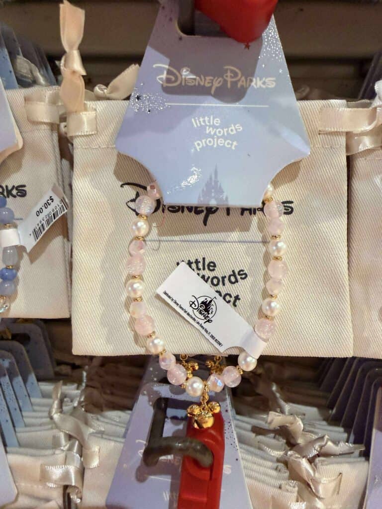 Pink and white Disney Parks necklace with pearl beads and gold accents.