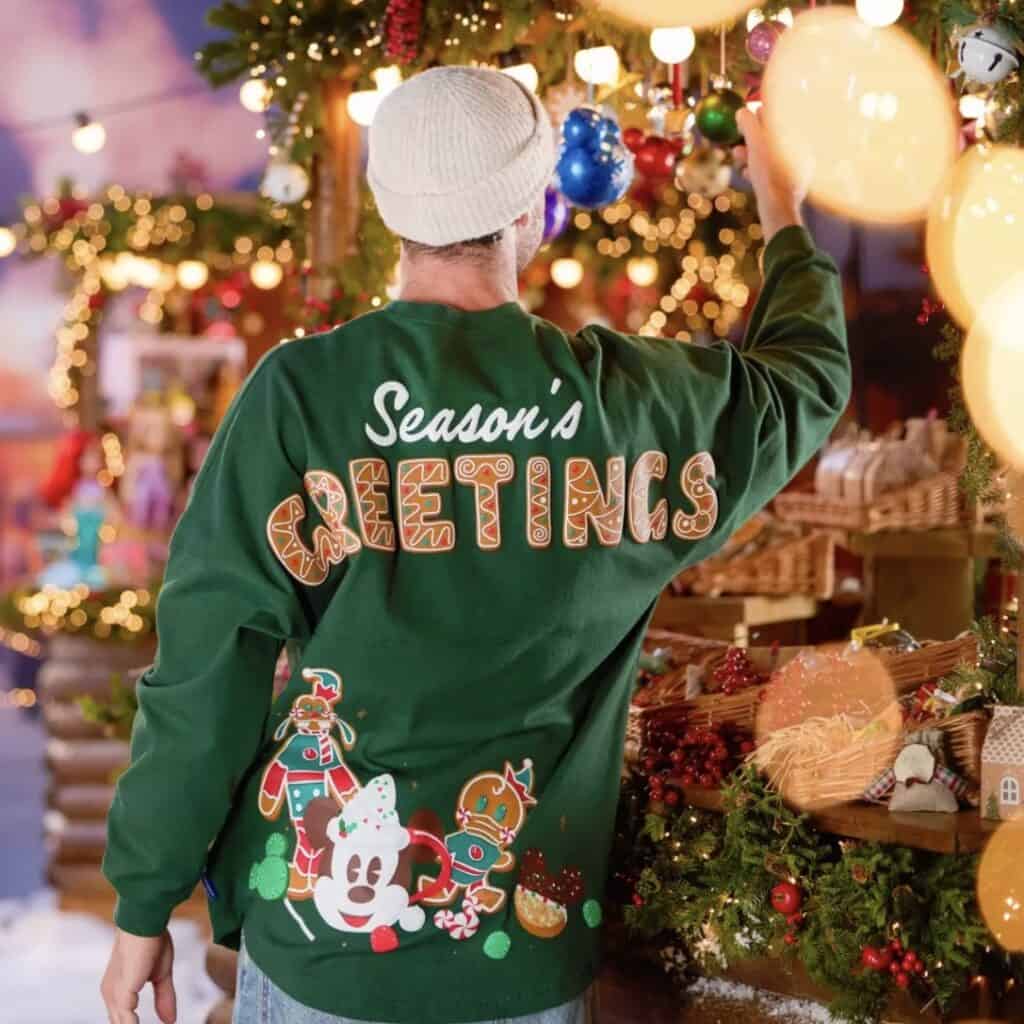Festive Christmas sweater with holiday decorations and gingerbread characters for seasonal Disney fashion.