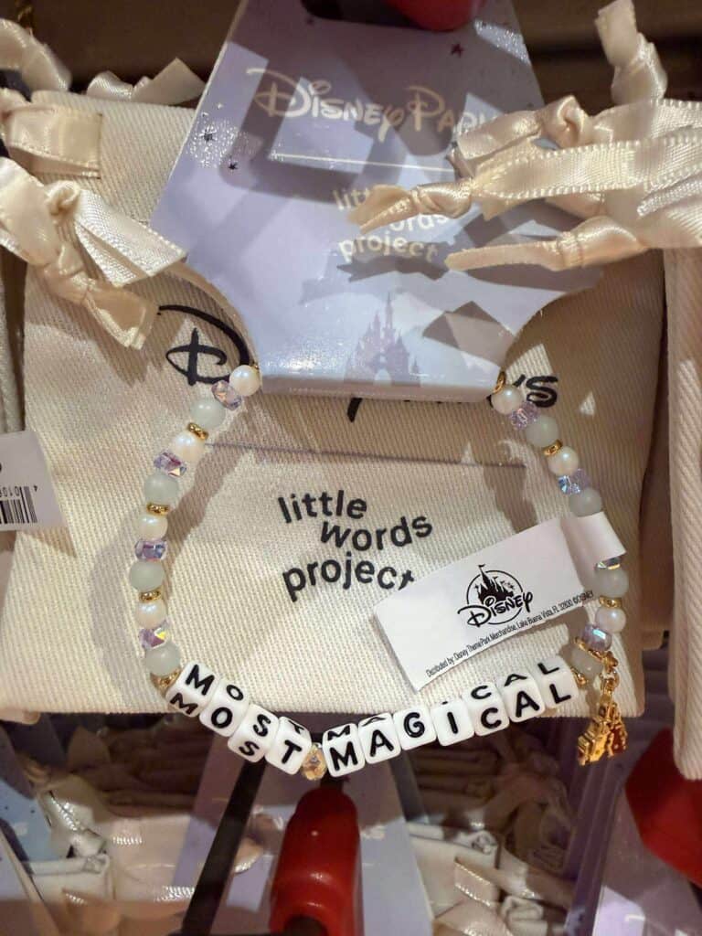 Bracelet with white and iridescent beads spelling "MOST MAGICAL" in black letter beads, Disney-themed jewelry for kids.