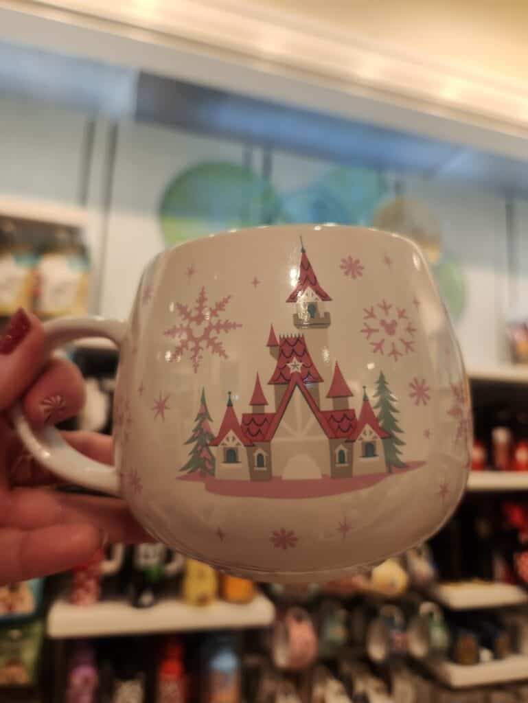Colorful Disney castle with Christmas theme on ceramic mug, perfect for Disney and holiday fans.