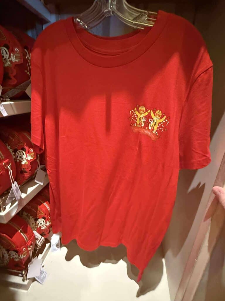 Red Disney T-shirt with gingerbread characters, festive holiday design, Disney fashion merch, Disney themed apparel, Christmas Disney clothing.