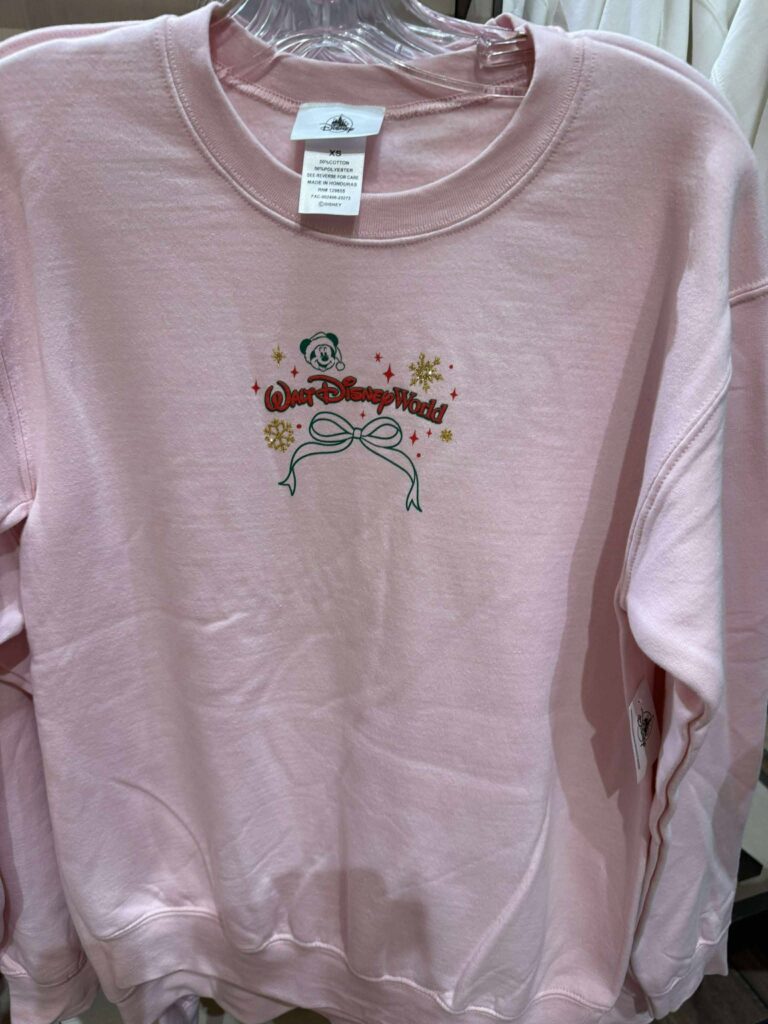 Walt Disney World pink holiday sweatshirt with festive logo and snowflakes.