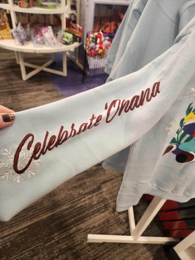 Embroidered Disney holiday sweater celebrating mom with "Celebrate Mom" on sleeve, perfect for Christmas gift.
