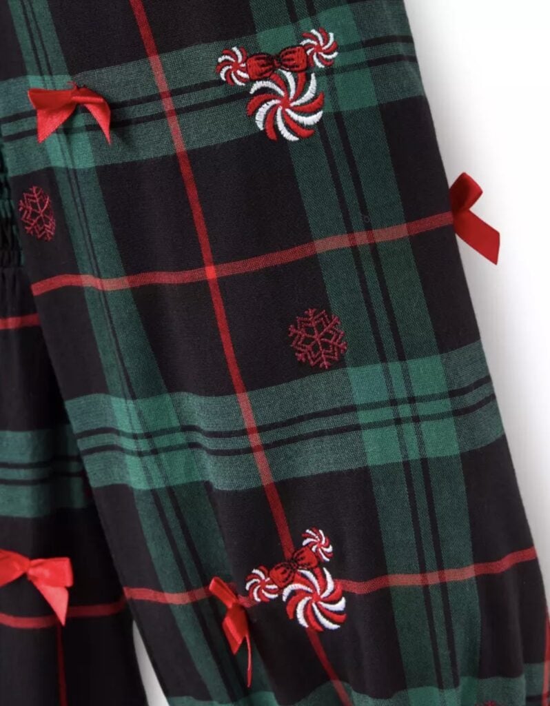 Festive Disney-themed holiday dress with red bows, peppermint and snowflake embroidery, perfect for Christmas celebrations.