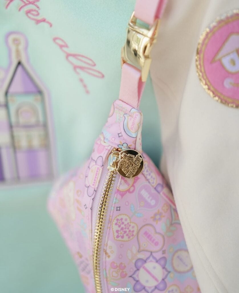 Pastel pink Disney-themed backpack with gold zipper and charm, perfect for Disney fashion accessories and style.