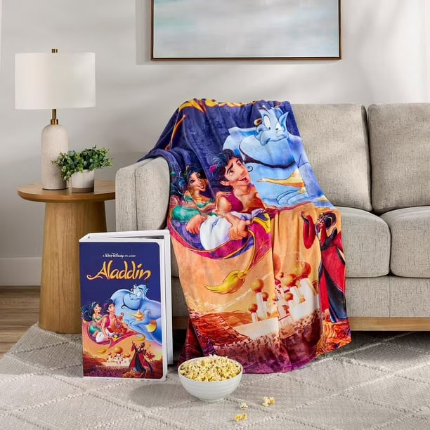 Aladdin Disney blanket featuring Jasmine, Aladdin, and Genie draped over sofa.