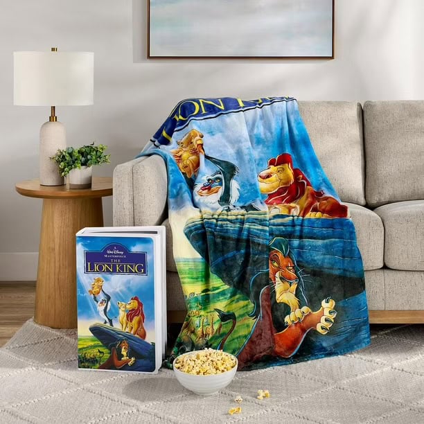Vibrant The Lion King blanket with characters Simba, Timon, and Pumbaa displayed on sofa.