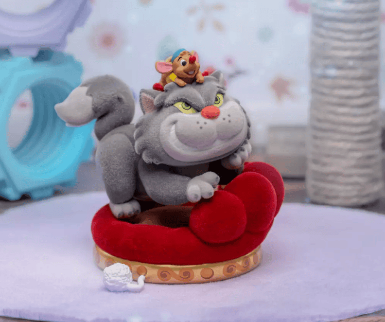 Decorative Disney Cat plush toy with a small mouse on a colorful pedestal.