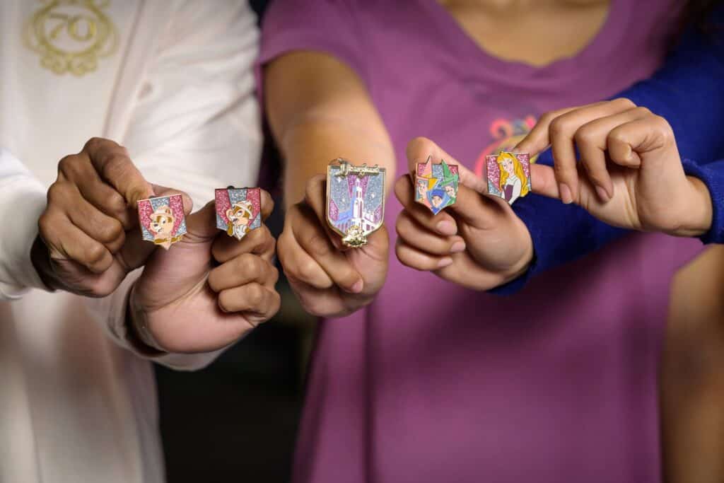 Colorful Disney princess pins and charms featuring Aurora, Ariel, Rapunzel, and more, perfect for Disney fans.