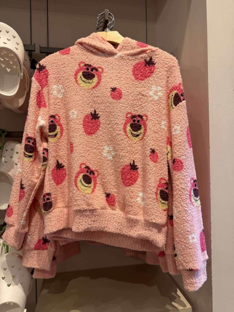 Colorful pink hoodie with fun bear and strawberry patterns from Disney fashion line.