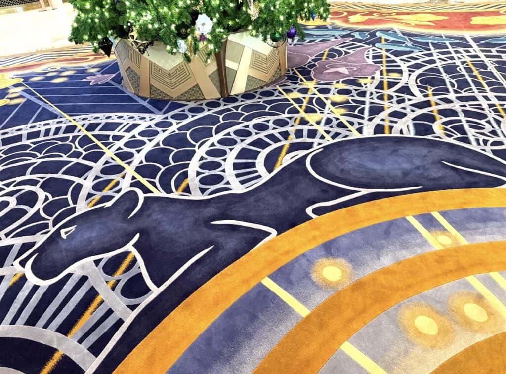 Decorative Disney-inspired carpet with horse silhouette and intricate patterns at a festive event.