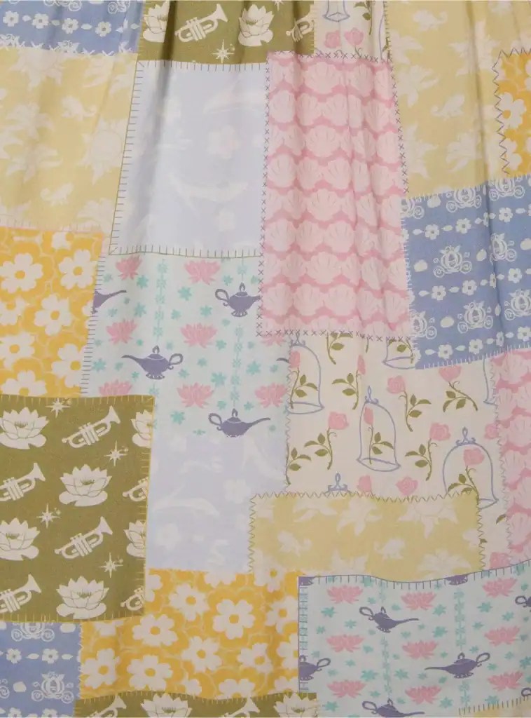 Colorful Disney-themed patchwork fabric with floral, musical, and fairy tale motifs.