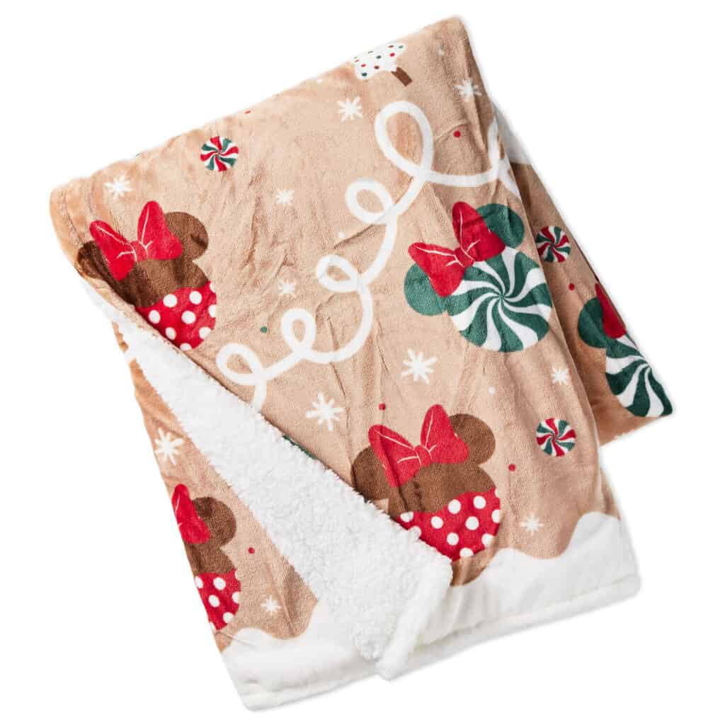 Soft plush Disney Minnie Mouse fleece blanket with holiday-themed print, perfect for winter comfort and Christmas cheer.