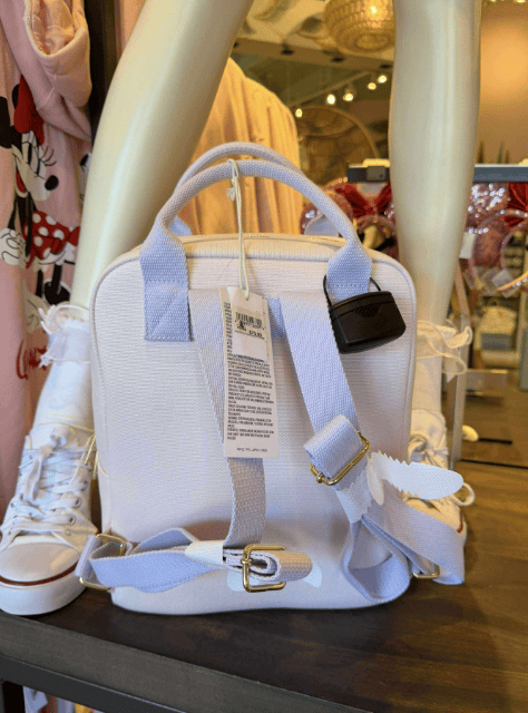Light blue Disney-themed handbag with adjustable strap and designer accents, perfect for Disney fashion lovers.