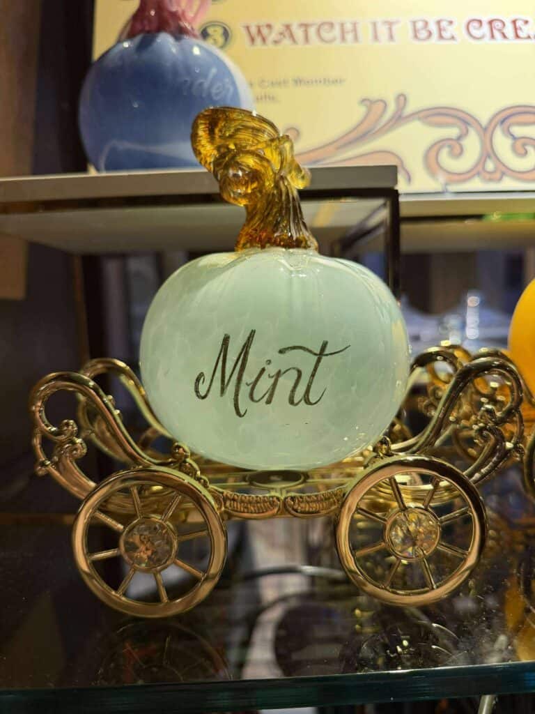 Elegant mint-green glass ornament shaped like a carriage with “Mint” inscribed, ideal for Disney-themed home décor or collectibles.