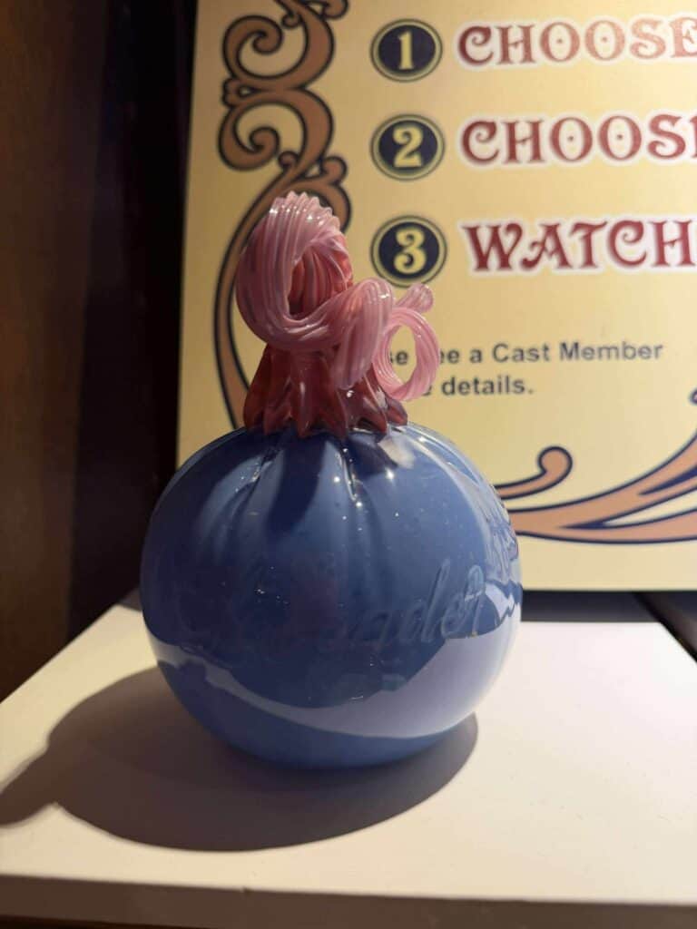 Delicate pink glass Disney-inspired fairy tale character topper on a blue pumpkin-shaped glass base. Perfect for Disney-themed decor.