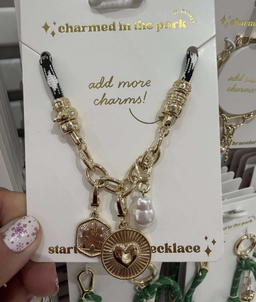 Detailed image of a Disney-inspired charm necklace with gold accents and pearl charm, perfect for Disney fashion lovers.