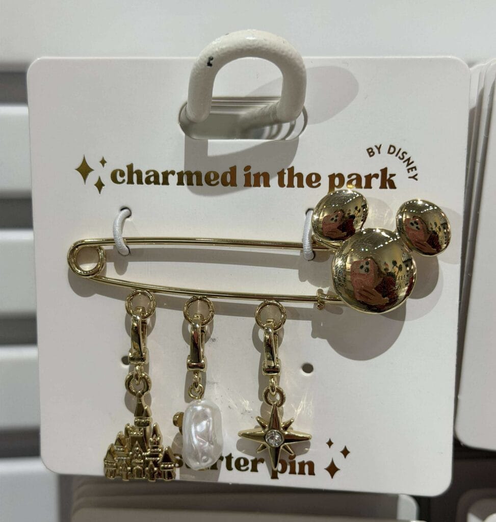 Gold Mickey Mouse themed pin and charm set with charms including a castle, pearl, and starburst.