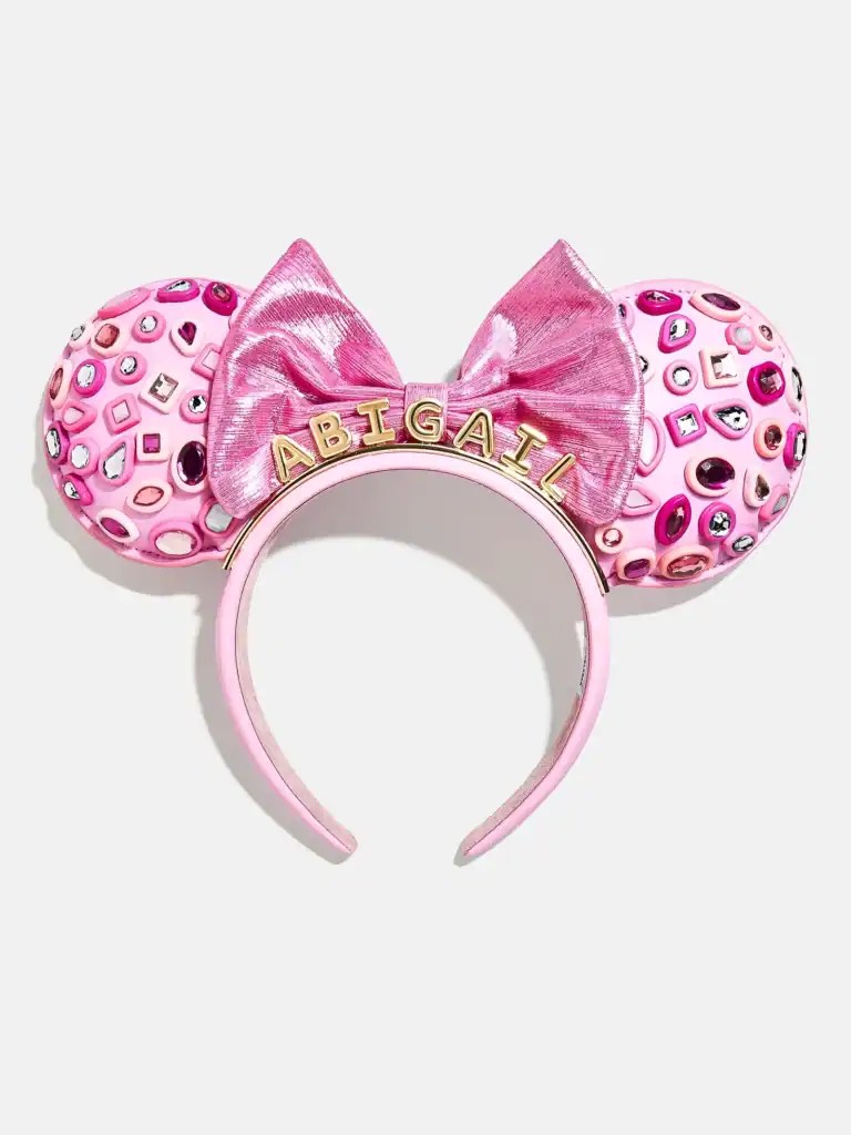 Pink Minnie Mouse ears headband with glitter, rhinestones, and pink bow, ideal for Disney-themed fashion.