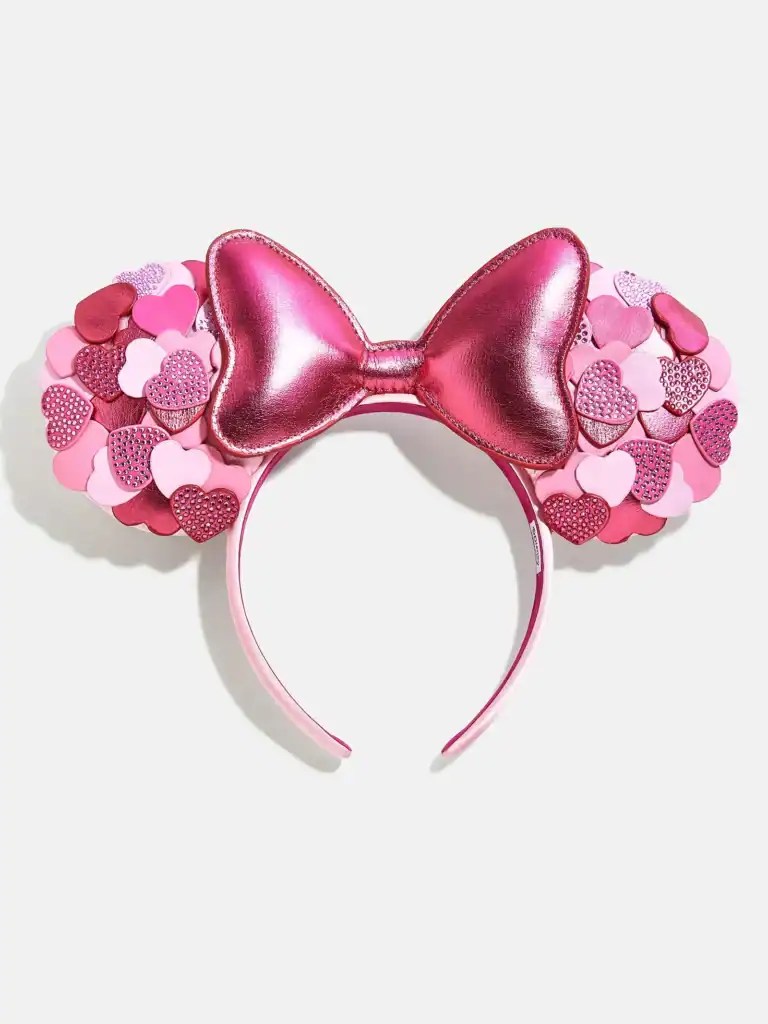 Pink Minnie Mouse ears headband with glittery heart accents and large bow, perfect for Disney fans of all ages.