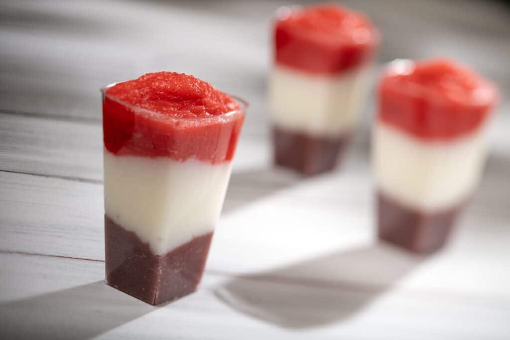 Delicious layered strawberry cheesecake parfaits with fresh strawberries, creamy cheesecake, and chocolate crust. Perfect for desserts.