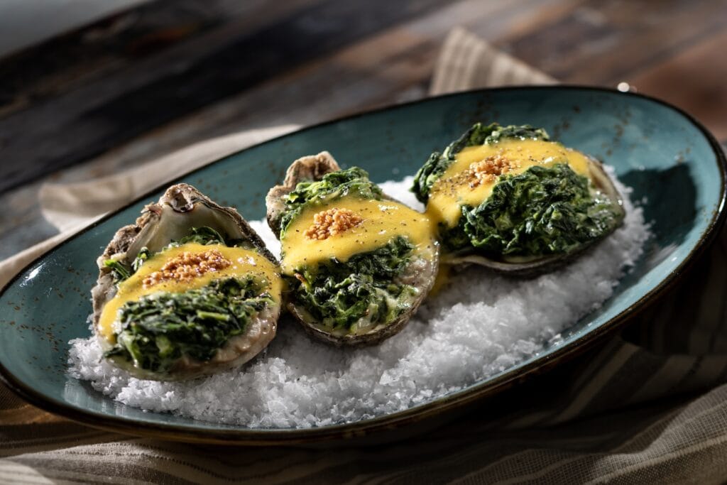 Fresh oysters topped with sautéed spinach, lemon sauce, and garnished with sesame seeds.