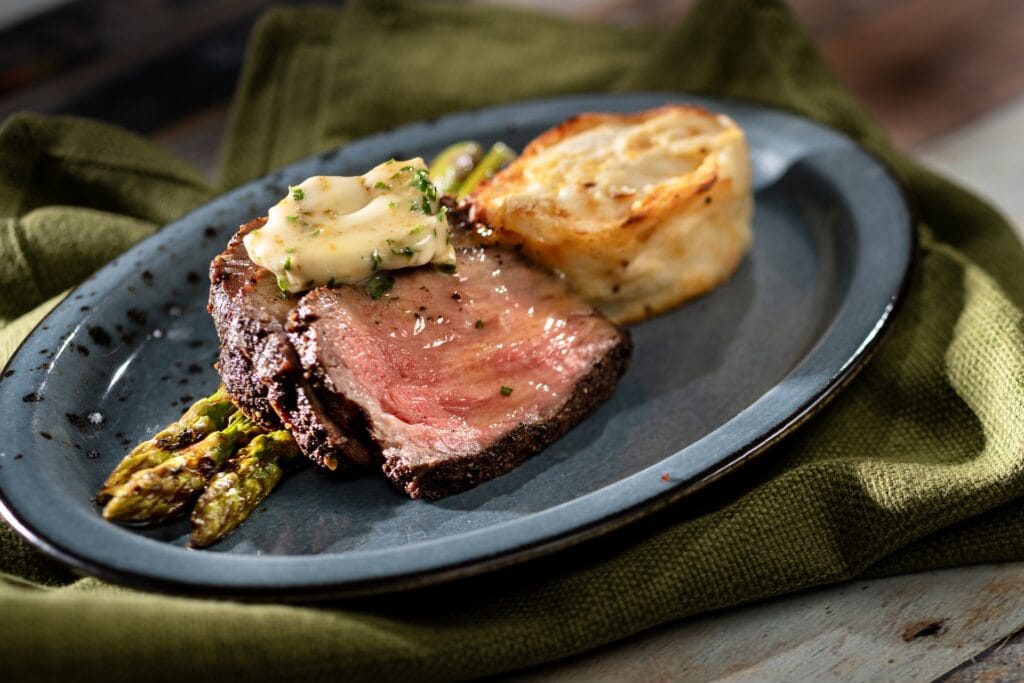 Delicious prime rib steak served with asparagus and creamy mashed potatoes, perfect for a gourmet dining experience.