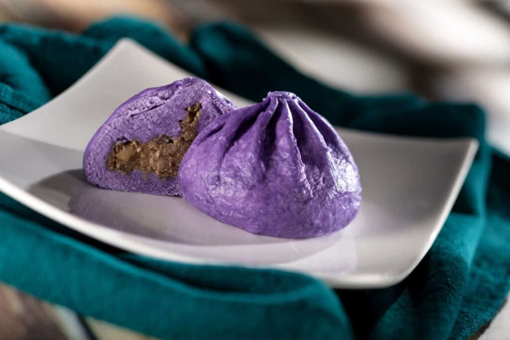 Vivid purple steamed dumplings filled with sweet and nutty filling, perfect for Disney-themed desserts.