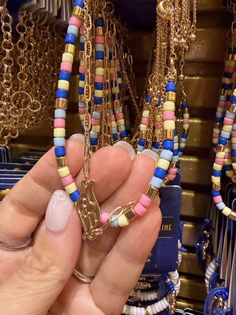 Bright beaded necklace with pastel pink, yellow, blue, and gold accents, perfect for Disney-inspired fashion.