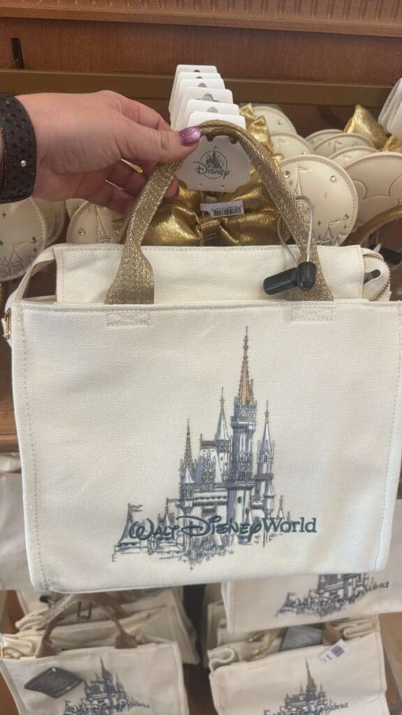 Disney World castle tote bag with gold handles, perfect for Disney fans and merchandise.